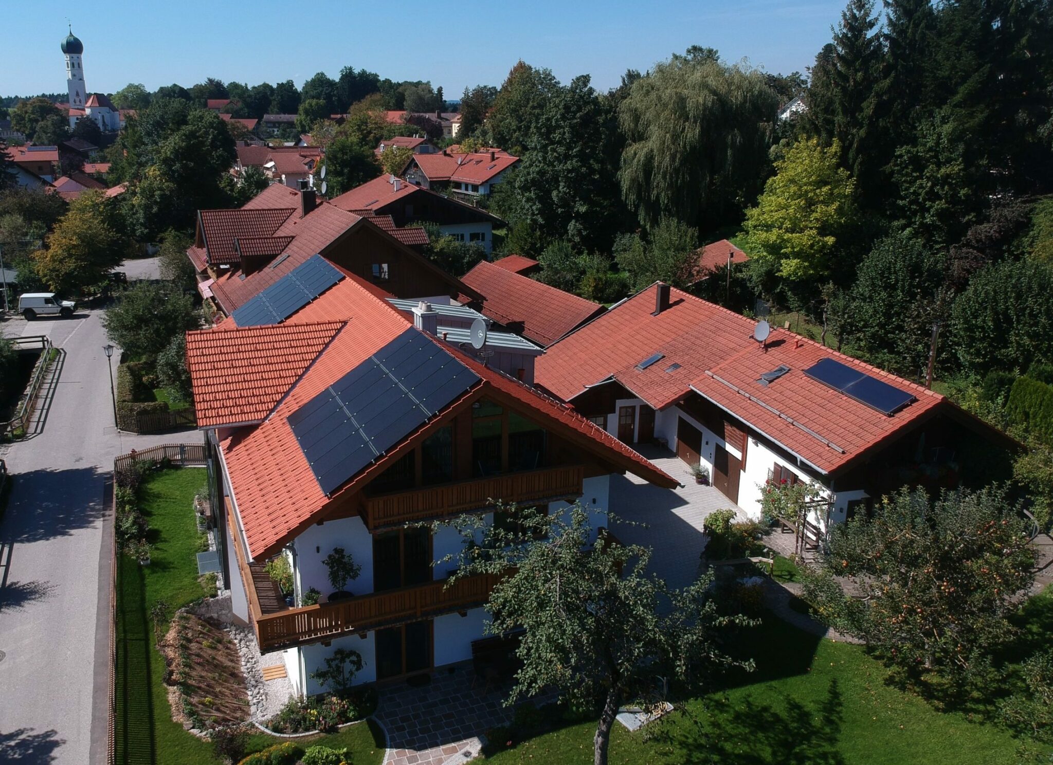 Luftaufnahme des Hauses Rothmeier-Strobl mit Photovoltaik-Dach und Garten in Münsing