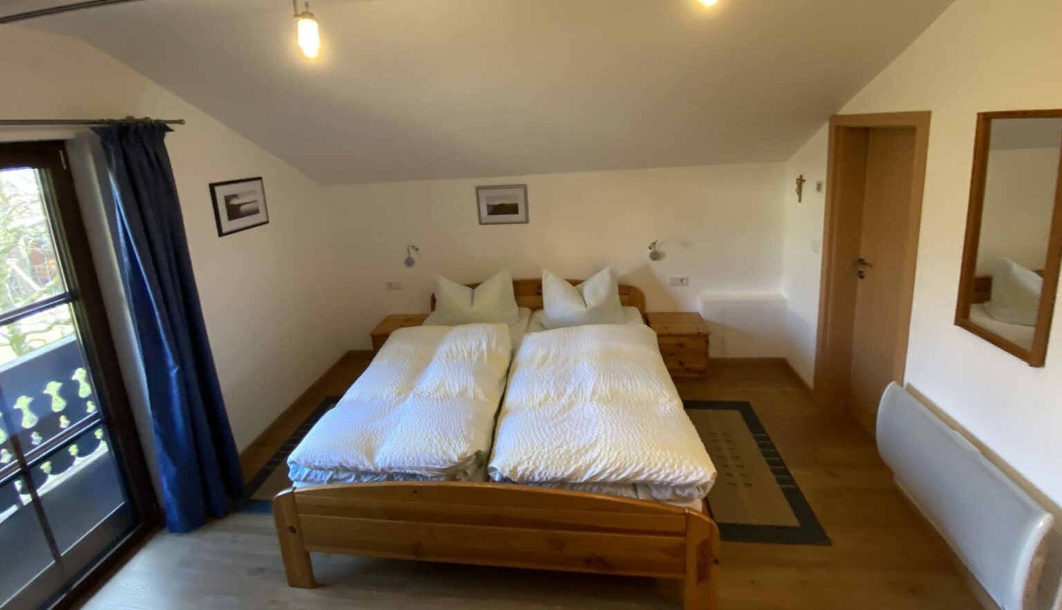 Schlafzimmer der Ferienwohnung 2 mit Doppelbett und Balkontür